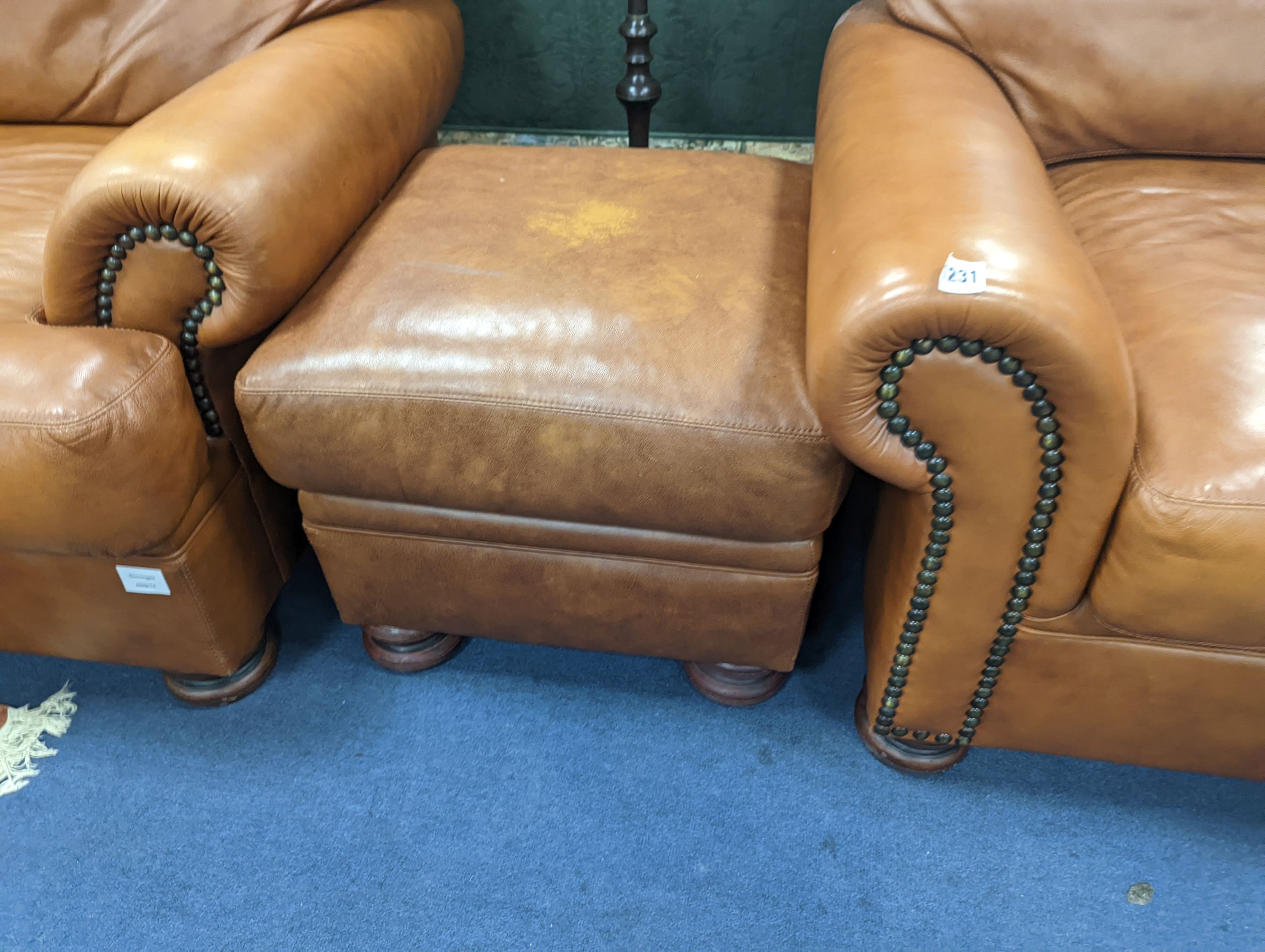 A contemporary tan leather three piece suite and footstool, settee length 150cm, depth 90cm, height 84cm
